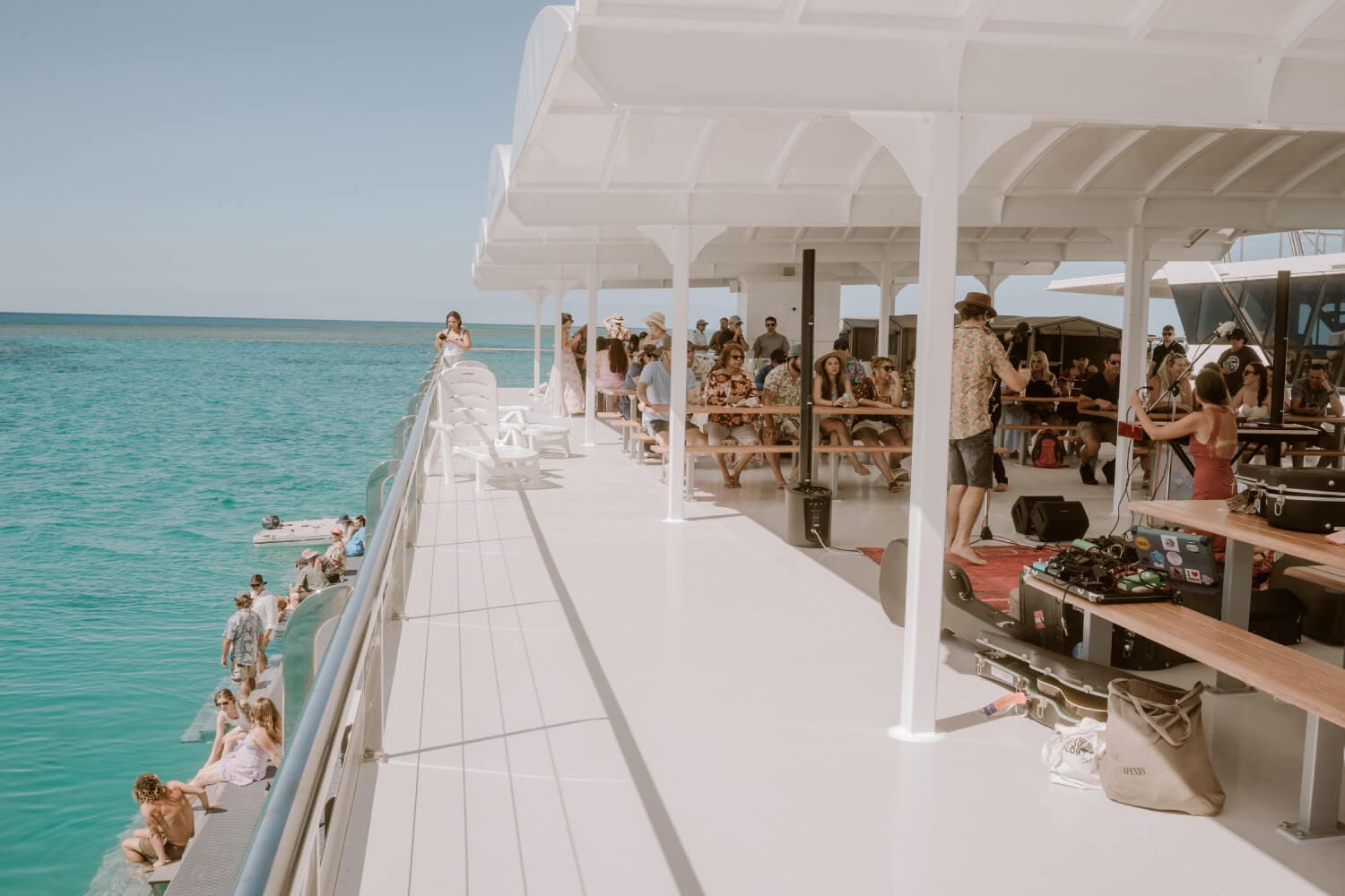 Guests on the deck of a chartered vessel in clear water